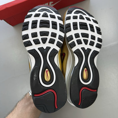Nike Air Max 97 gold trainers with white and black accents, featuring a sleek design.