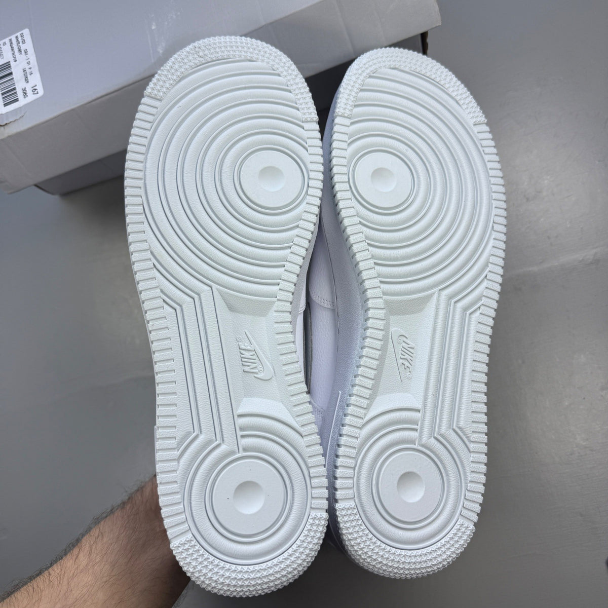 Nike Air Force 1 white trainers with pure platinum grey accents and classic logo.
