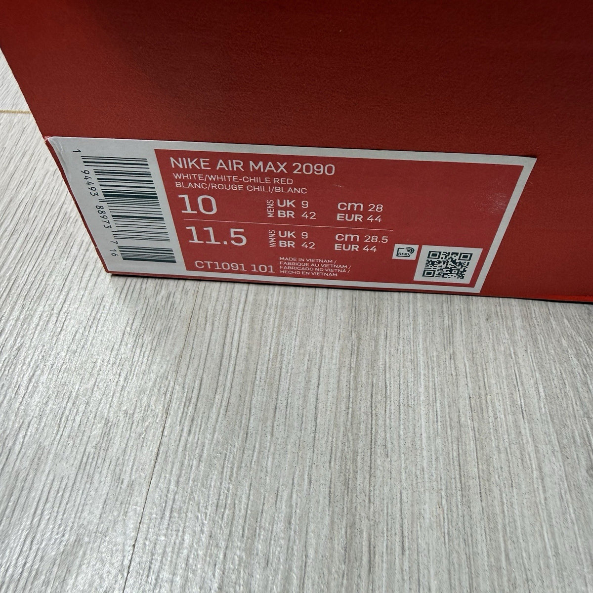 Nike Air Max 2090 trainers white with red and blue accents, featuring logo details.