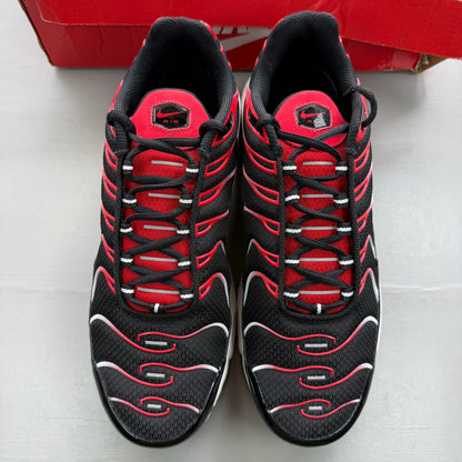 Nike Air Max Plus TN black trainers with white and university red accents, mesh material.