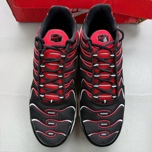 Nike Air Max Plus TN black trainers with white and university red accents, mesh material.