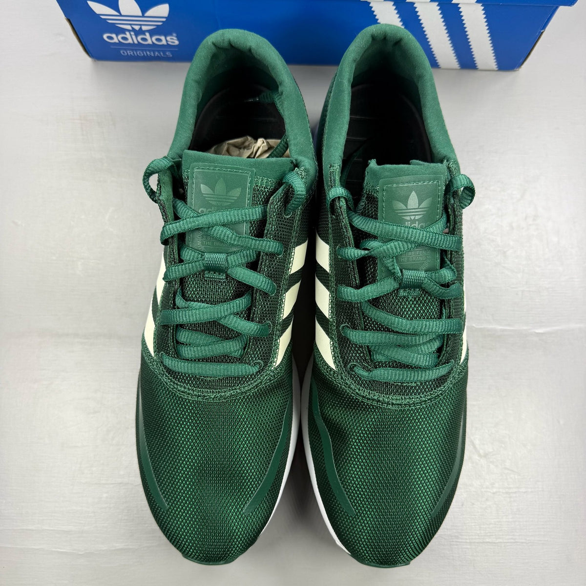 Adidas green trainers with white accents and logo detailing, brand new in box.