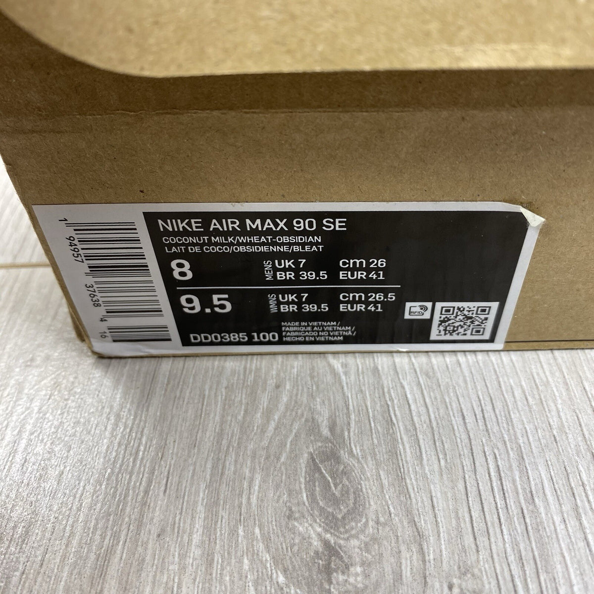 Nike Air Max 90 SE white trainers with cork accents and logo detail.