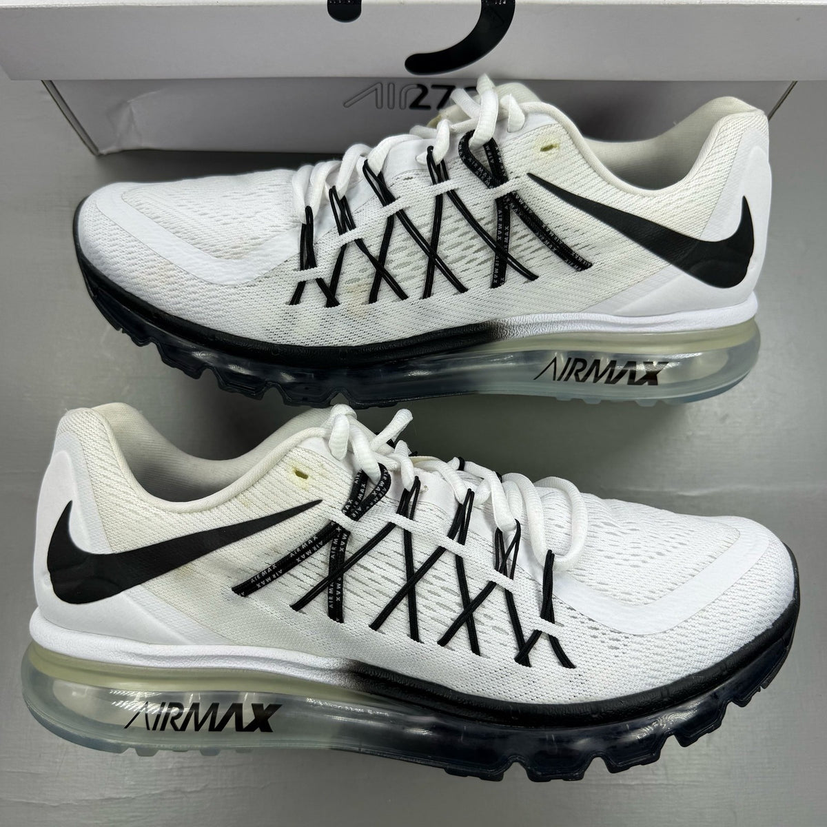 Nike Air Max 2015 white running shoes with black accents and logo detail.