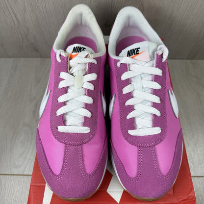 Nike white trainers with pink accents and gum sole, featuring iconic swoosh logo.