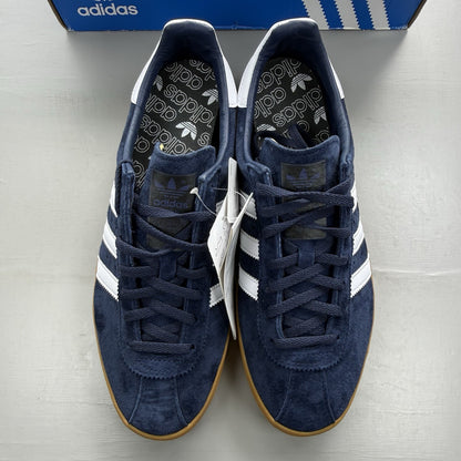 Adidas blue trainers with white and gum sole, featuring gold accents and logo.