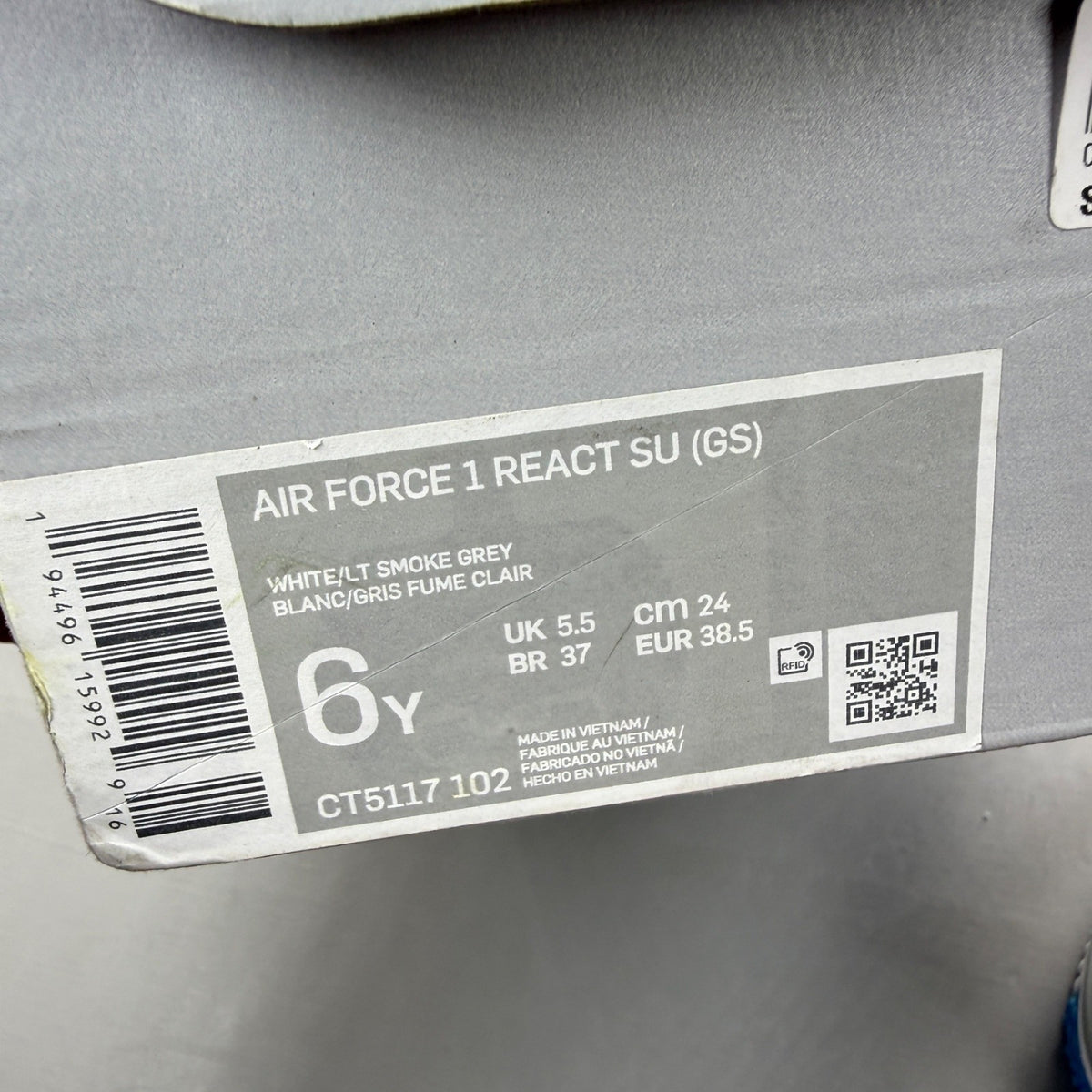 Nike Air Force 1 React white trainers with smoke grey accents and logo details.