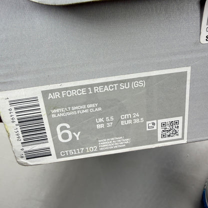 Nike Air Force 1 React white trainers with smoke grey accents and logo details.