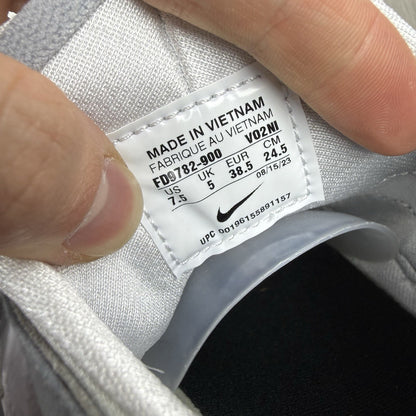 Nike white trainers with grey accents and signature logo on the tongue.