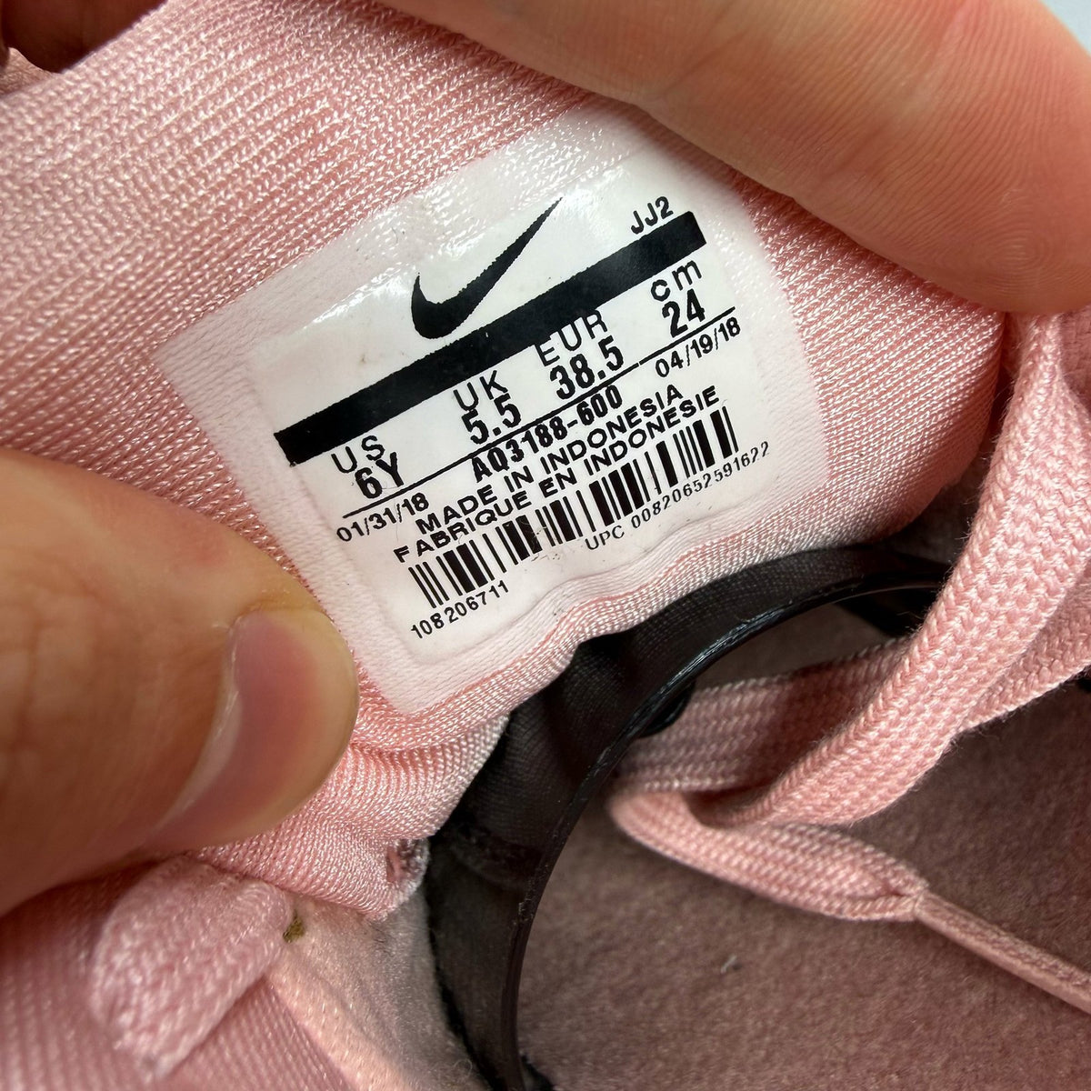 Nike Air Max 1 pink trainers with white accents and logo details.