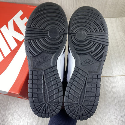 Nike Dunk Low trainers black and white with iconic swoosh logo and smooth leather upper.