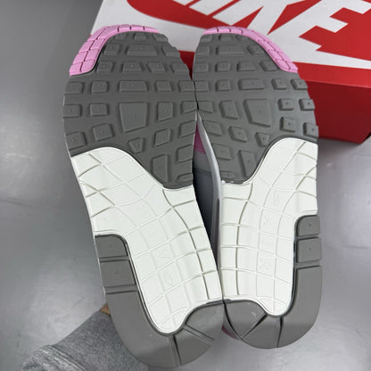 Nike Air Max 1 trainers pink with metallic accents and classic logo detailing.