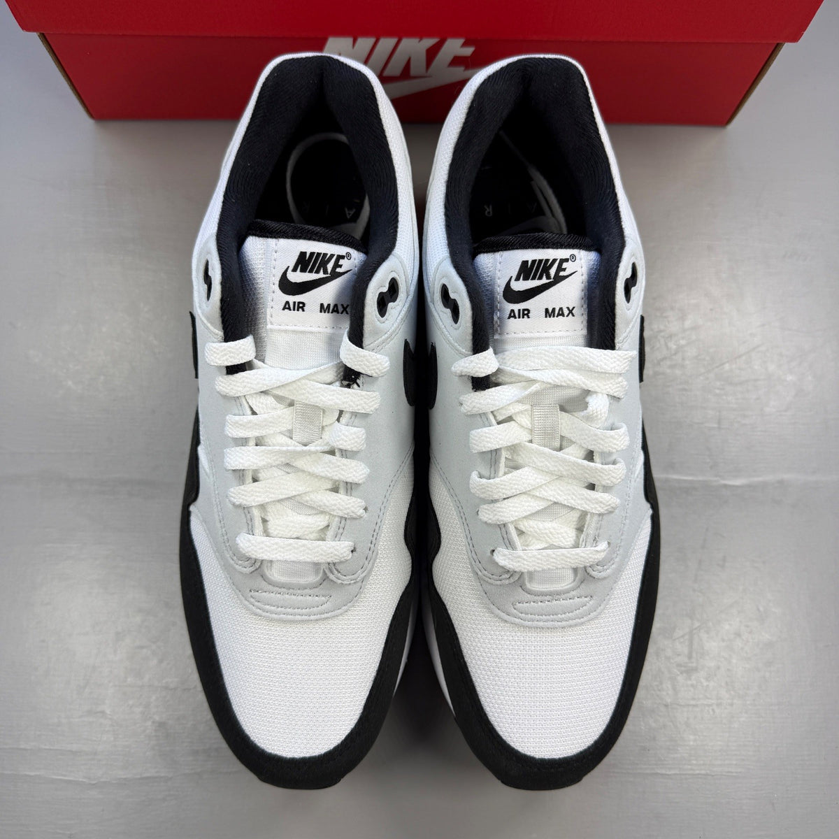Nike trainers white with black and platinum grey accents, featuring iconic swoosh logo.