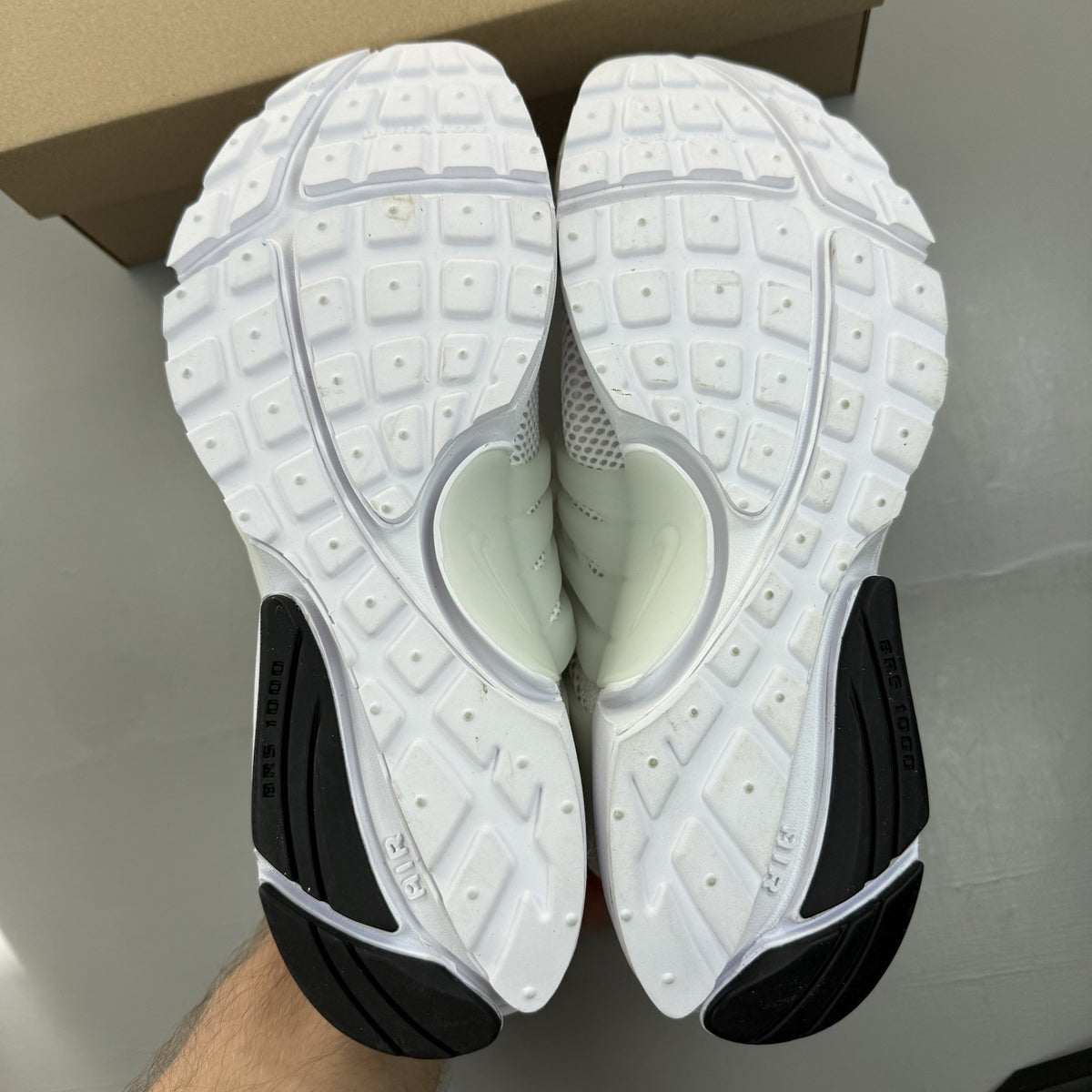 Nike Air Presto white trainers with black accents and mesh upper.