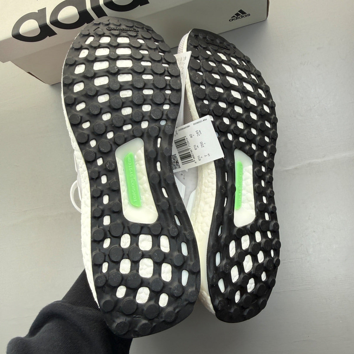 Adidas Ultra Boost 1.0 white running trainers with textured knit upper and signature three stripes.