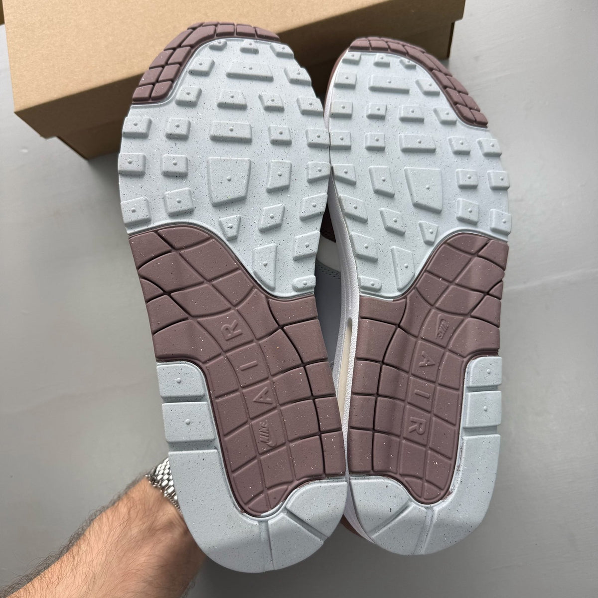 Nike Air Max 1 brown trainers with premium Shima Shima pattern and logo details.