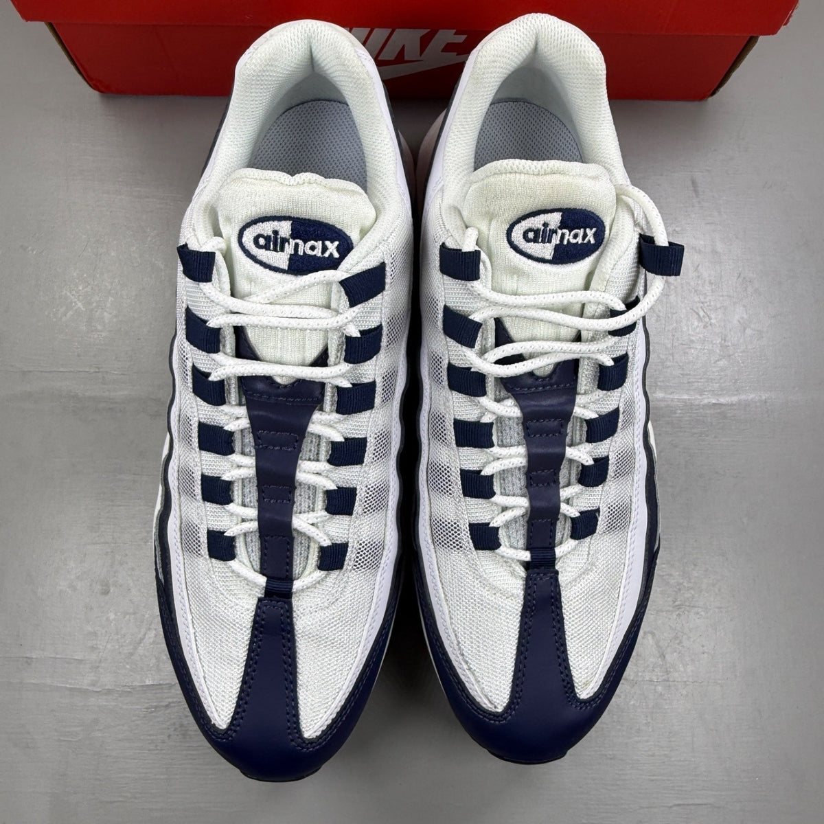 Nike Air Max 95 white trainers with navy accents and signature logo detailing.