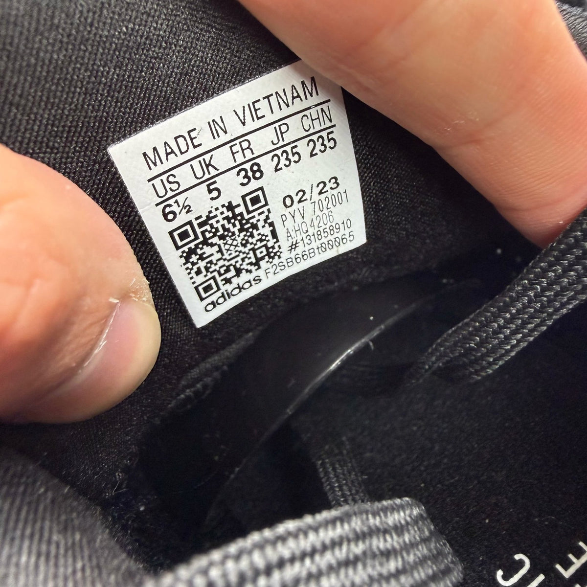 Adidas Ultraboost 1.0 black trainers with white accents and signature three-stripe logo.