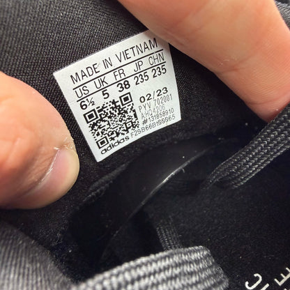 Adidas Ultraboost 1.0 black trainers with white accents and signature three-stripe logo.