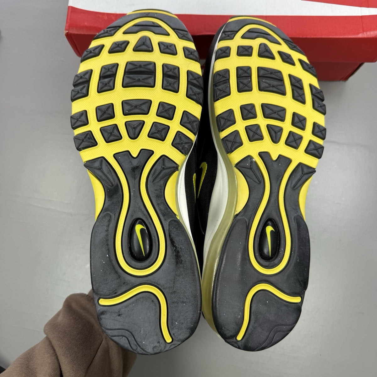 Nike Air Max 97 black trainers with opti yellow accents and white sole.