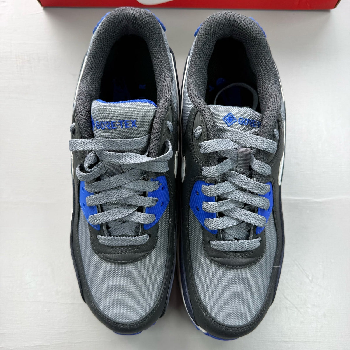 Nike Air Max 90 grey sneakers with Gore-Tex material and blue accents.