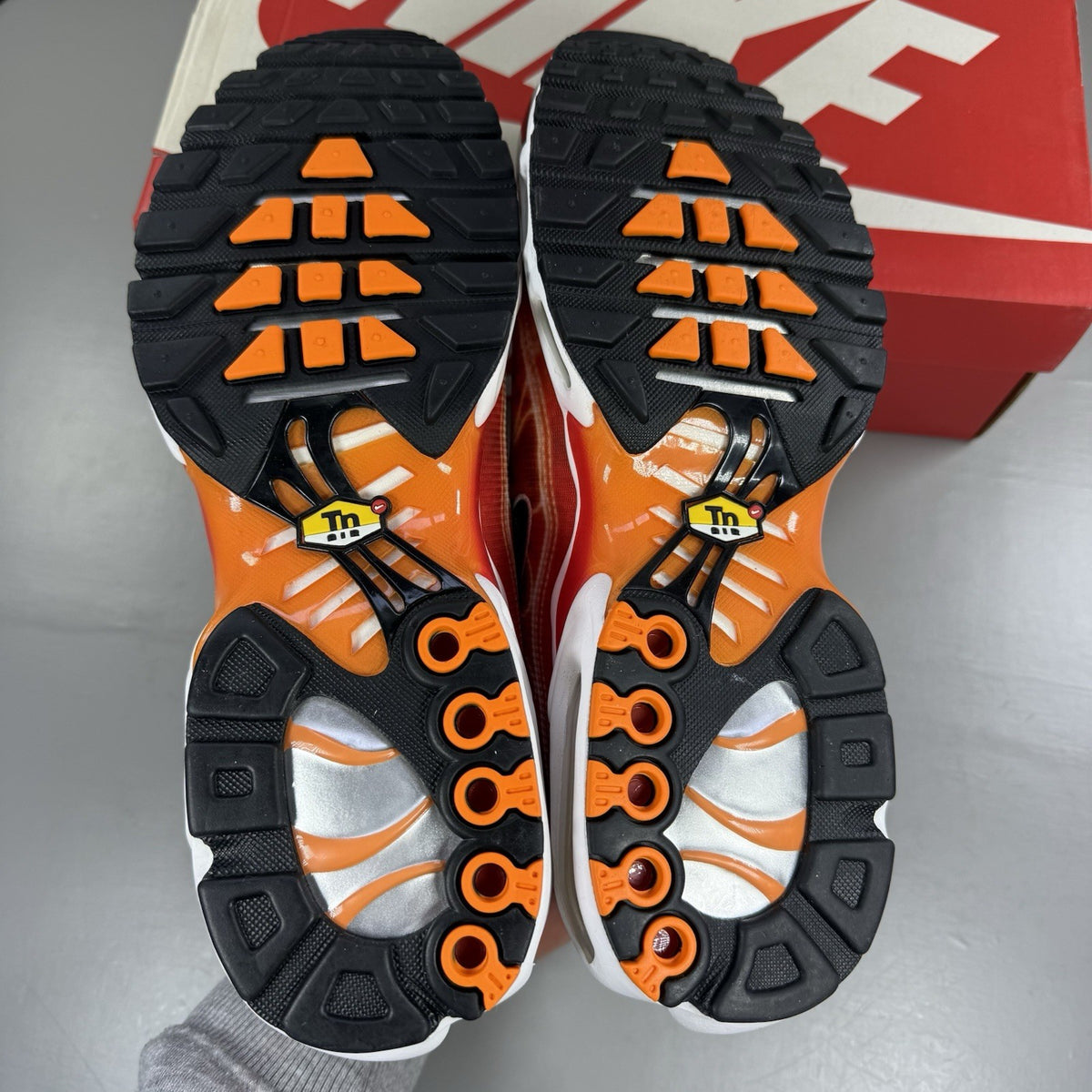 Nike Air Max Plus TN trainers in light photography orange with distinctive wavy design.