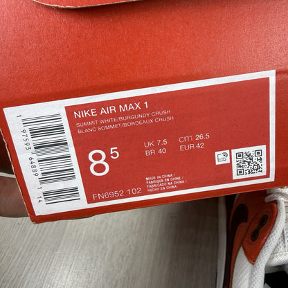 Nike Air Max 1 red trainers with white accents and signature swoosh logo.