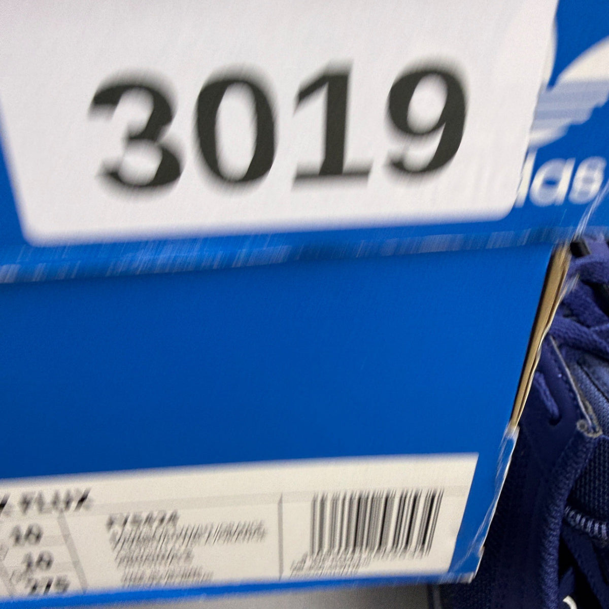 Adidas blue trainers with black accents and signature three-stripe logo.