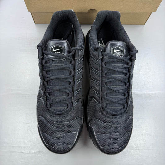 Nike Air Max Plus TN black trainers with distinctive wave pattern and logo detail.