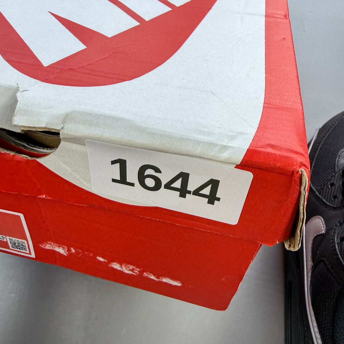 Nike Air Max 90 Premium black trainers with silver reflective accents and logo details.