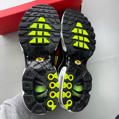 Nike Air Max Plus TN black trainers with light crimson and volt accents, logo on tongue.