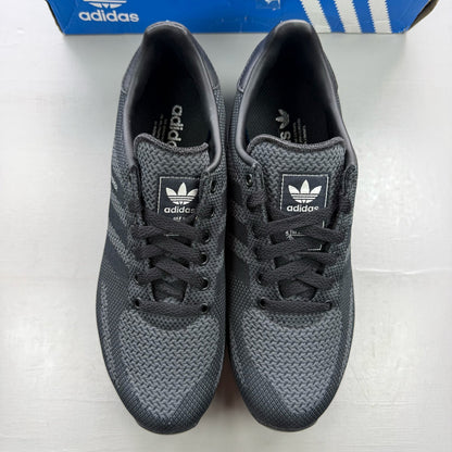 Adidas black grey LA Trainer sneakers with woven upper and iconic three-stripe logo.