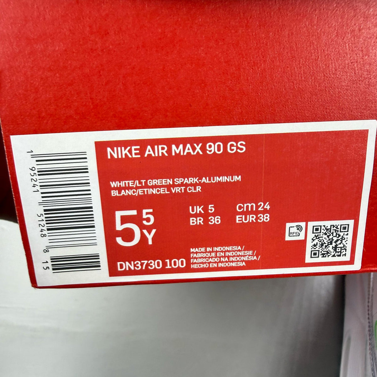 Nike Air Max 90 GS white trainers with multi-coloured Swoosh logo and mesh detailing.