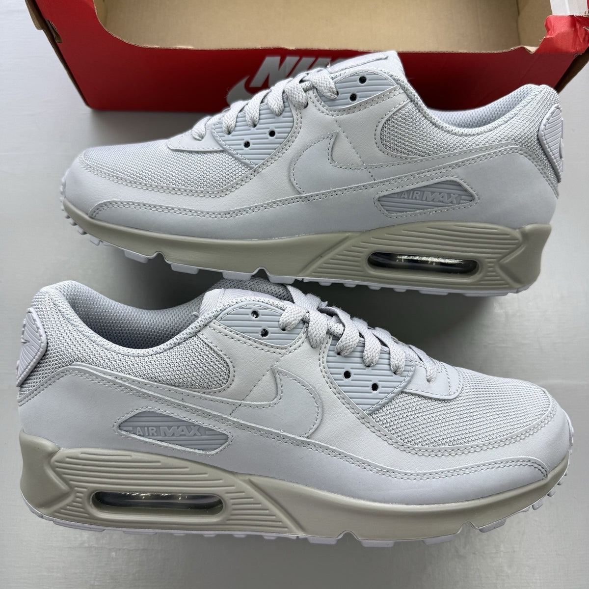 Nike Air Max 90 Recraft grey trainers with iconic swoosh logo and mesh detailing.