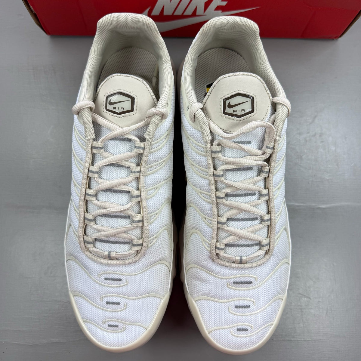 Nike Air Max Plus TN white trainers with signature logo and textured detailing.