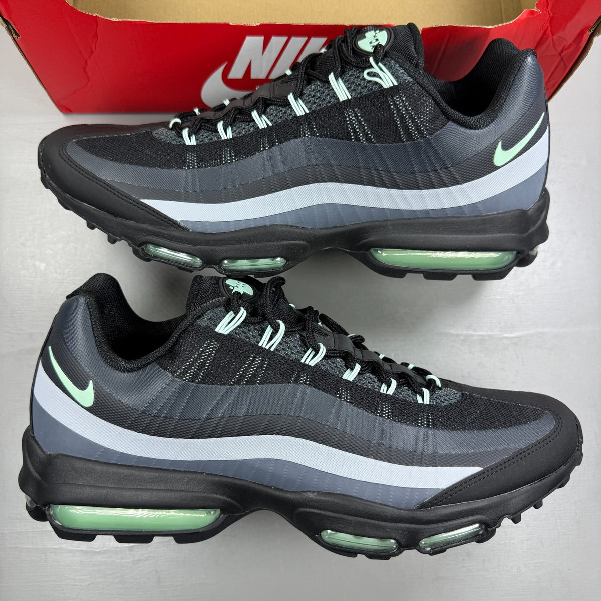 Nike running shoes black with mint foam accents and anthracite detailing.