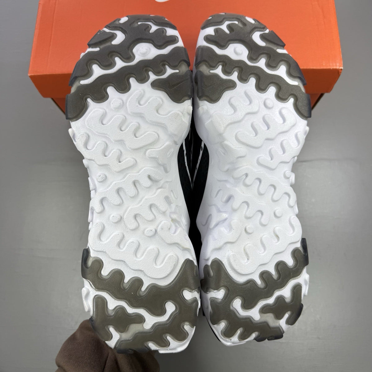 Nike React Vision black trainers with white accents and logo detailing.
