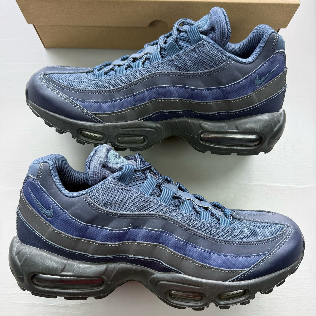 Nike Air Max 95 blue trainers with midnight navy accents and signature logo details.