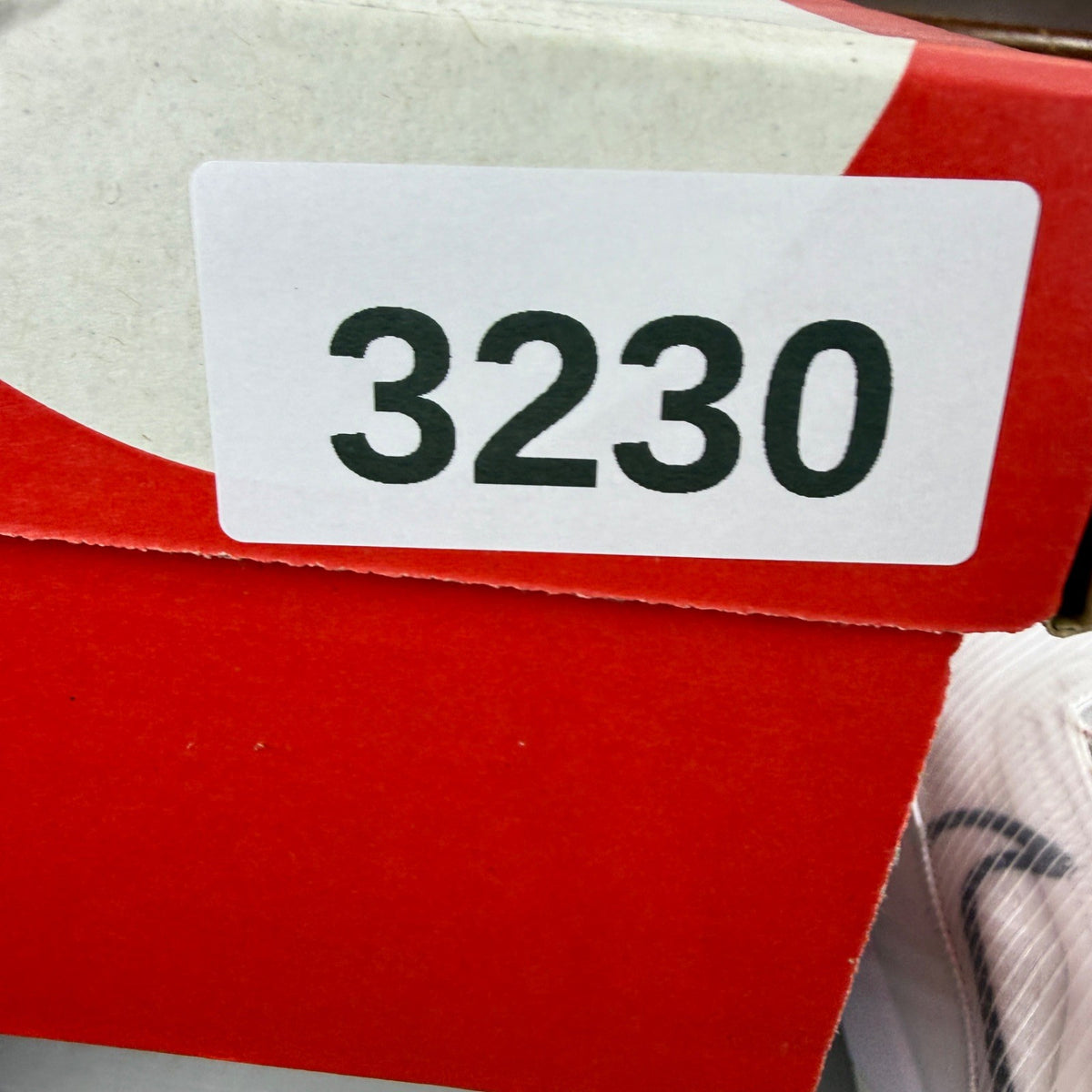 Nike running shoes white with red accents and logo, featuring a sleek design.
