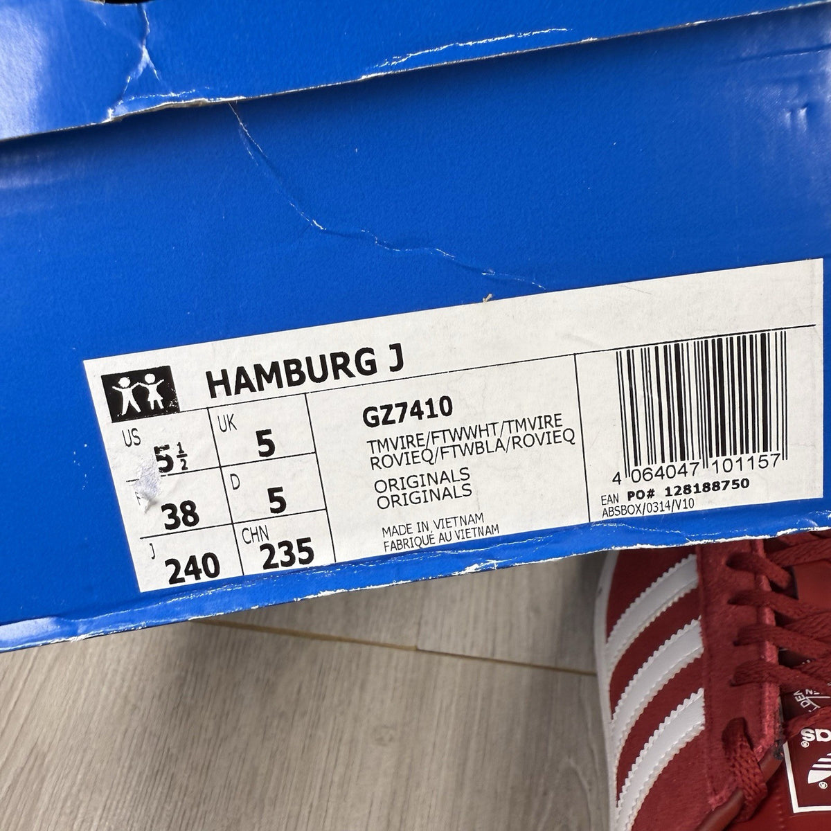 Adidas red trainers with white stripes and logo, classic suede material.