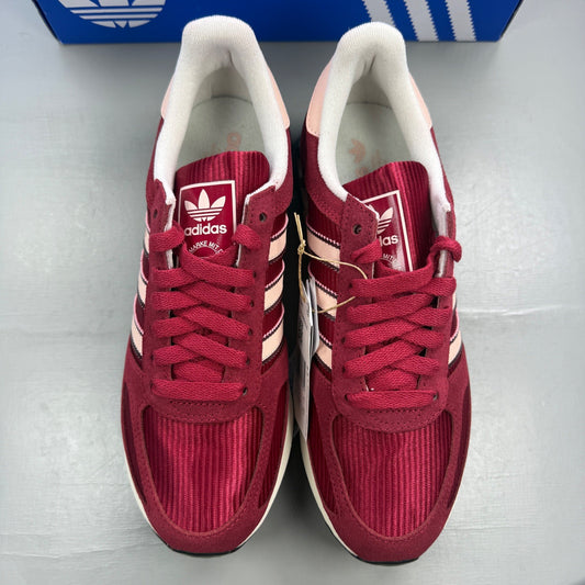 Adidas pink trainers with white stripes and logo, featuring a retro design.