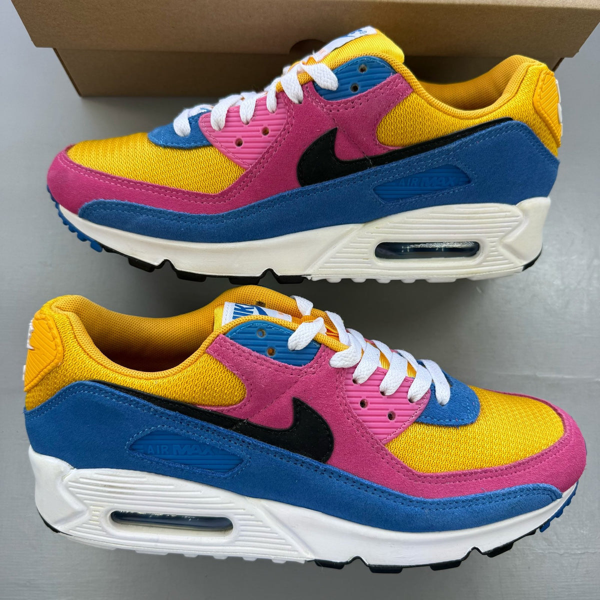 Nike Air Max 90 multicolor suede trainers with yellow and blue accents.