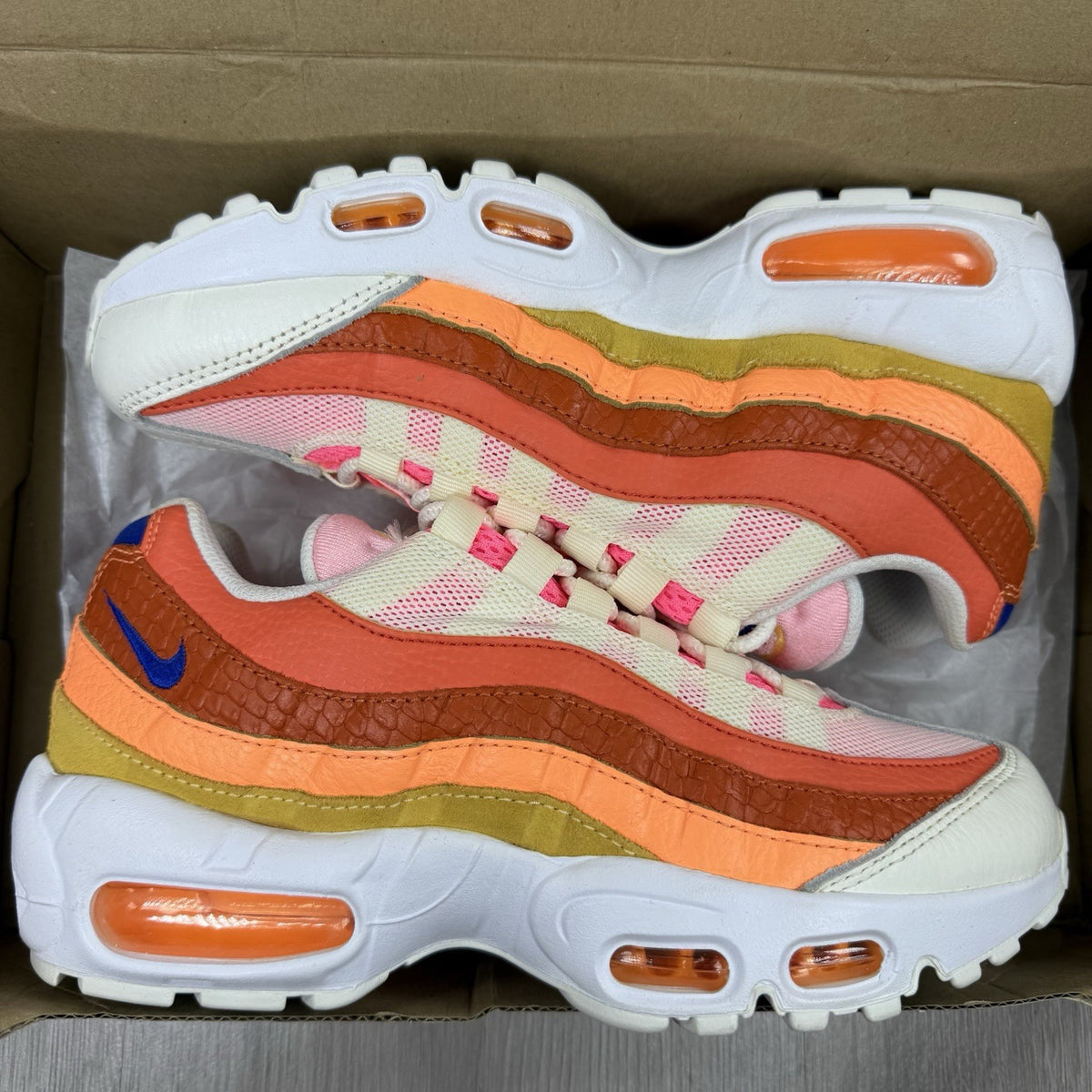 Nike Air Max 95 trainers white with campfire orange accents and signature logo details.