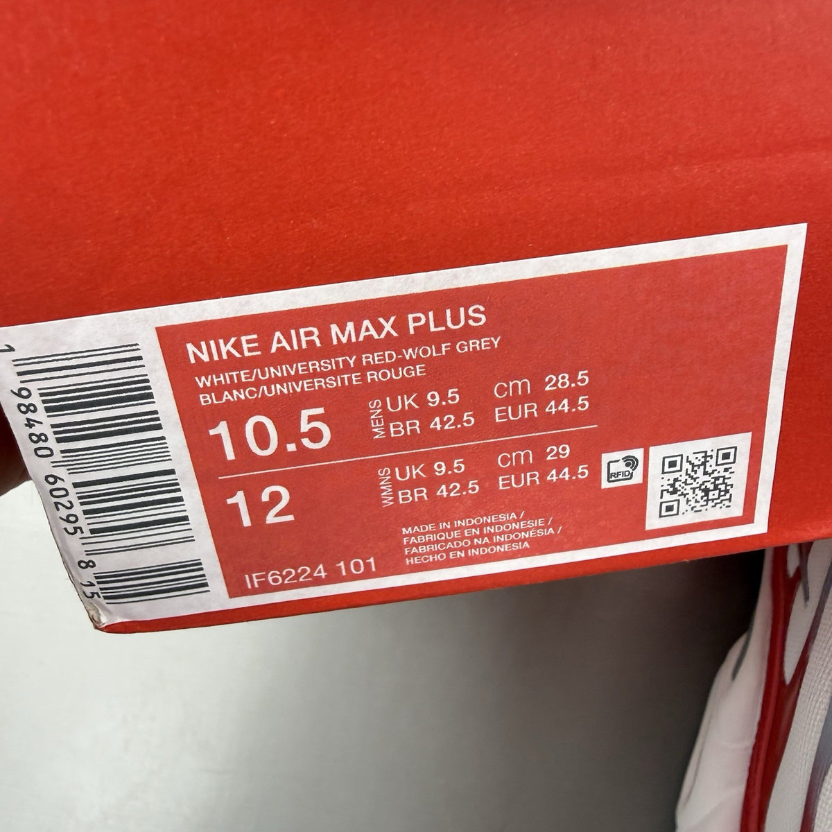 Nike Air Max Plus TN white trainers with university red and grey accents, featuring signature logo.