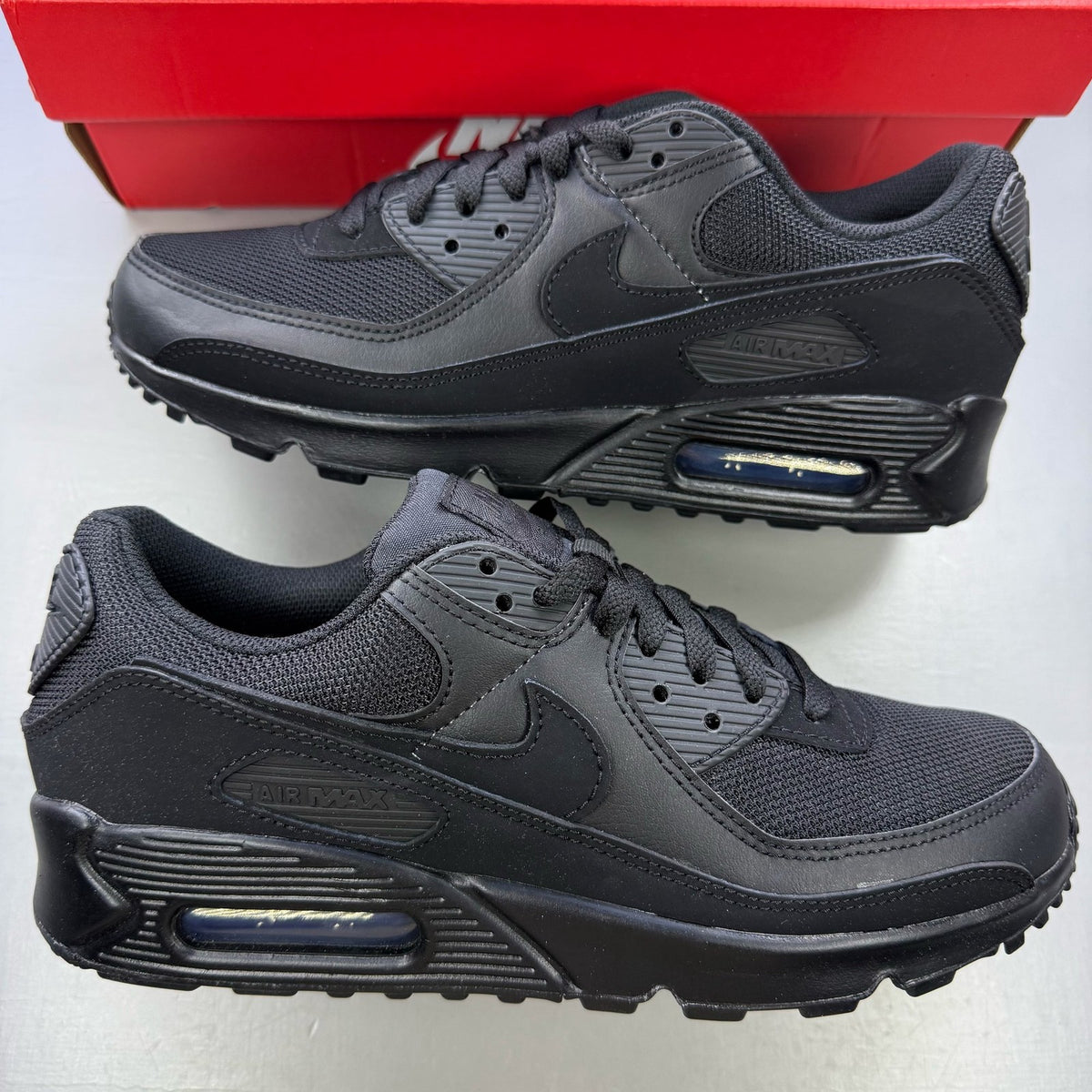 Nike Air Max 90 trainers black with signature logo and sleek design.