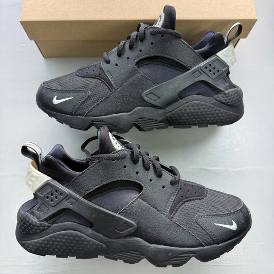Nike black Air Huarache trainers with metallic silver mini swoosh logo.