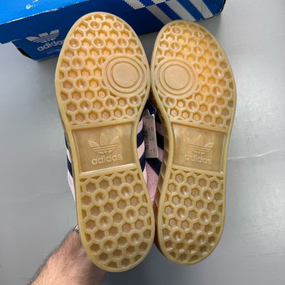 Adidas pink trainers with gum sole, featuring iconic three stripes logo.