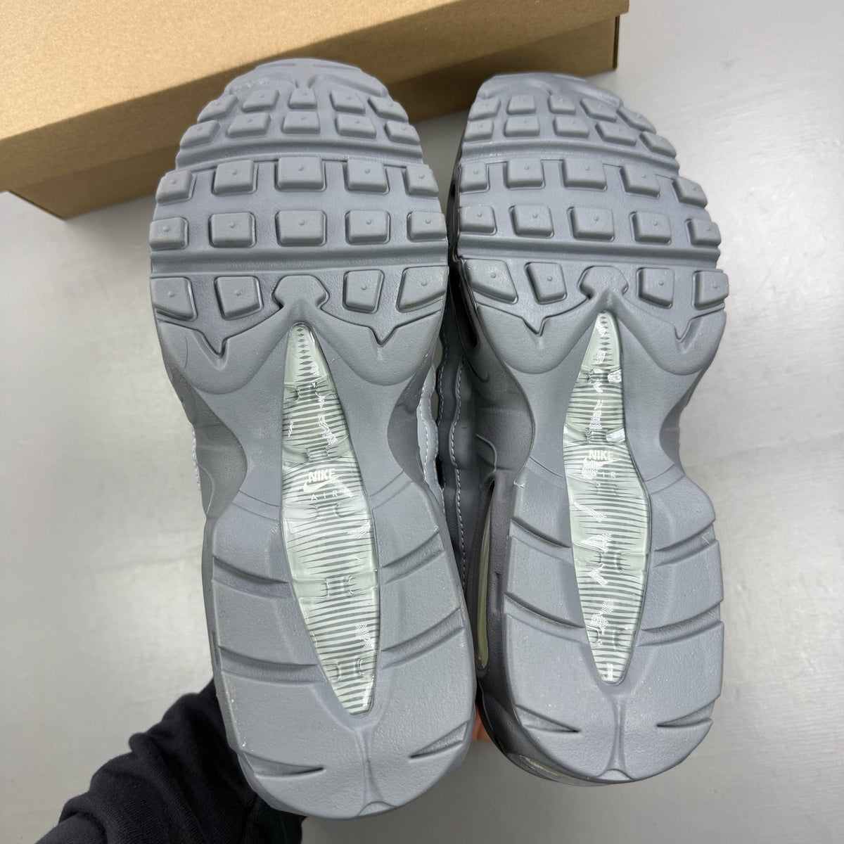 Nike Air Max 95 grey trainers with white accents and signature logo details.