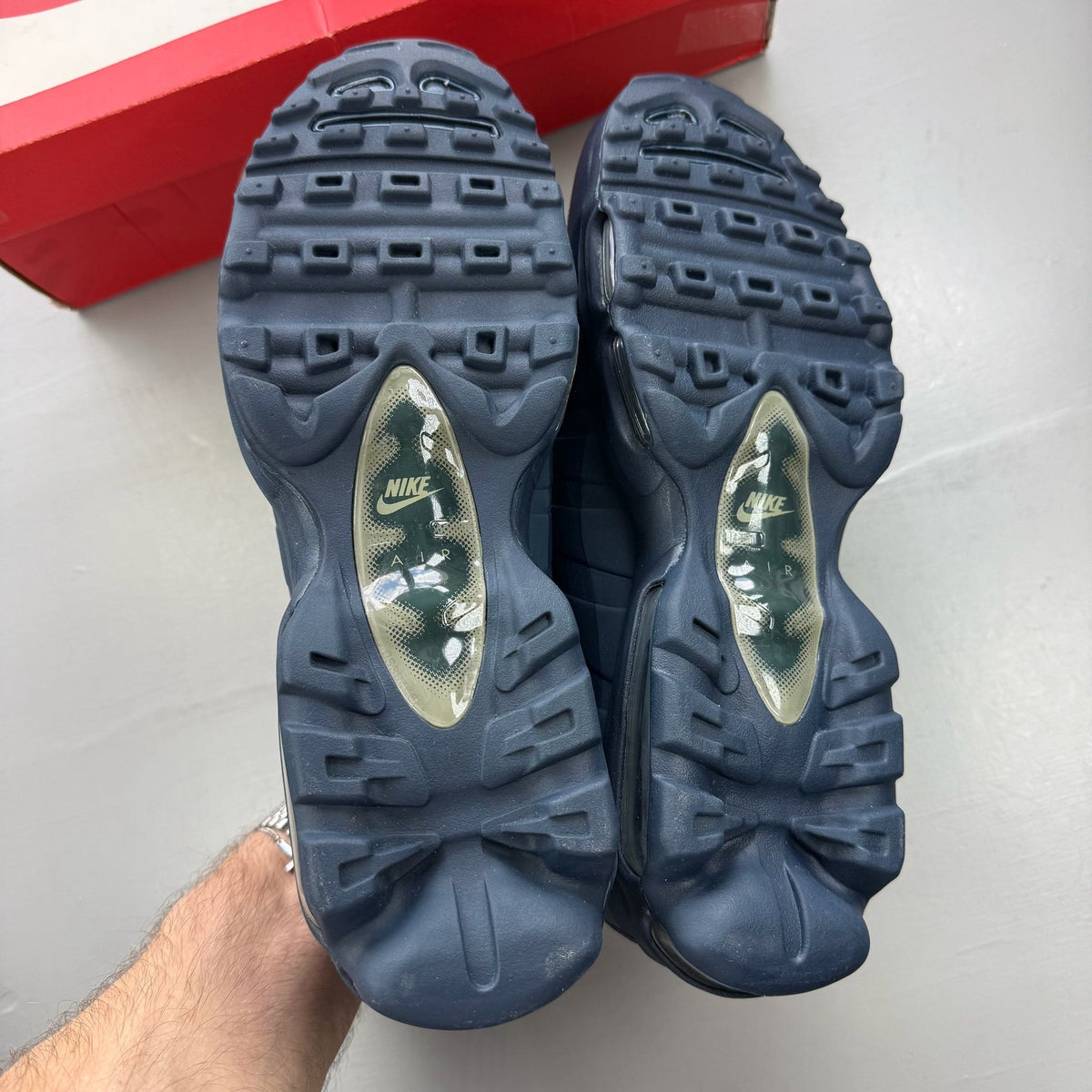 Nike Air Max 95 blue trainers with mesh upper and rubber sole, featuring logo detail.