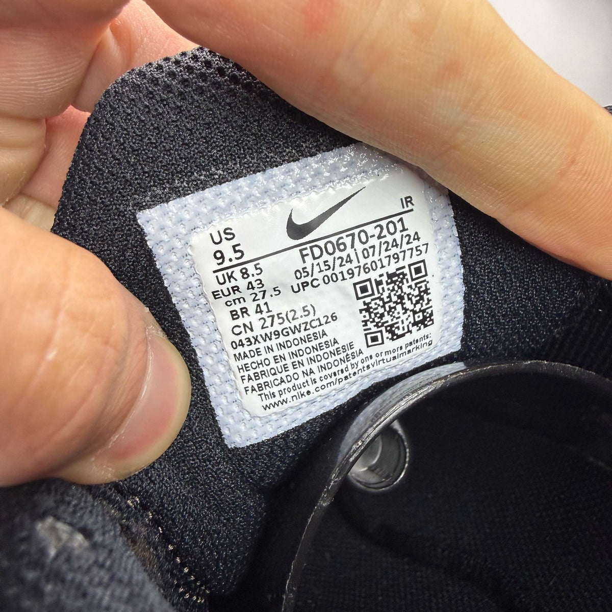 Nike Air Max Plus TN black trainers with distinctive wave pattern and cushioned sole.